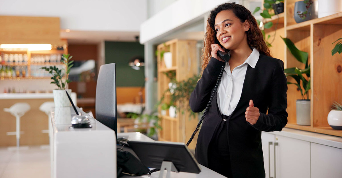 Hotel concierge assists guest using S-NET's PMS Integration and Unified Hospitality Communications Platform solutions.
